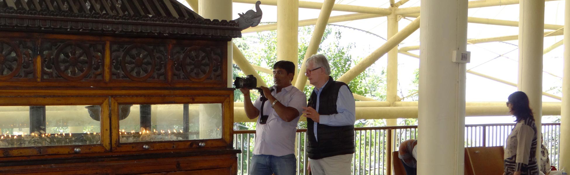 Director and DOP Avinash Kumar holding a professional camera while filming a documentary inside the Tsuglagkhang Complex (Dalai Lama Temple) in McLeod Ganj, Himachal Pradesh, India. film shooting locations in Balod, video shooting locations in Balod, tv shooting locations in Balod, shooting locations in Balod
