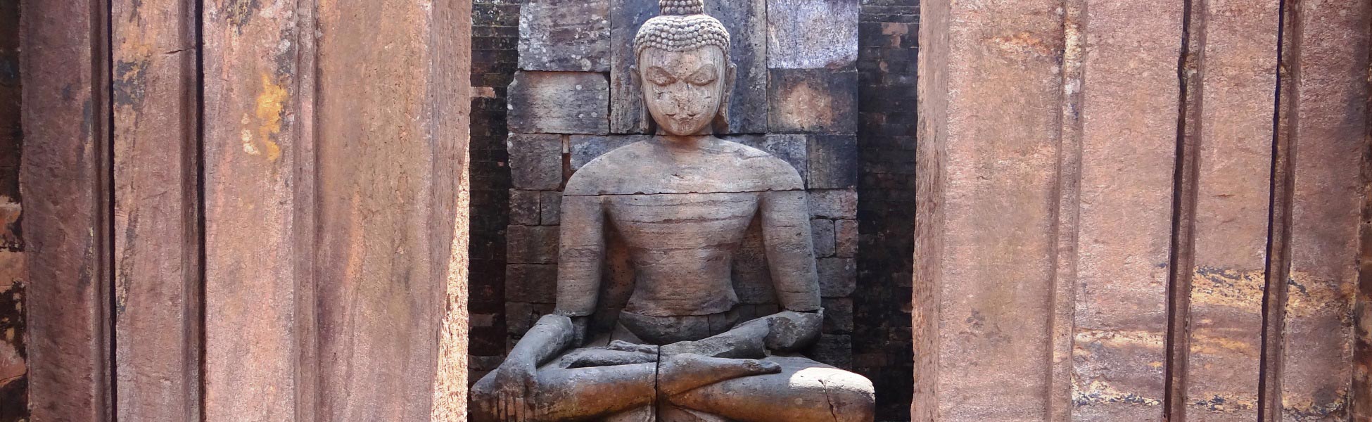 A colossal ancient stone carving of Lord Buddha seated inside a brick recess niche flanked by stone columns at the Udayagiri Buddhist monastery ruins in Jajpur district, Odisha, India—an elite cinematic location option for documentary and historical filmmakers. film production house in Barnala, video production house in Barnala, tv production house in Barnala, production house in Barnala, film production company in Barnala, video production company in Barnala, tv production company in Barnala, production company in Barnala