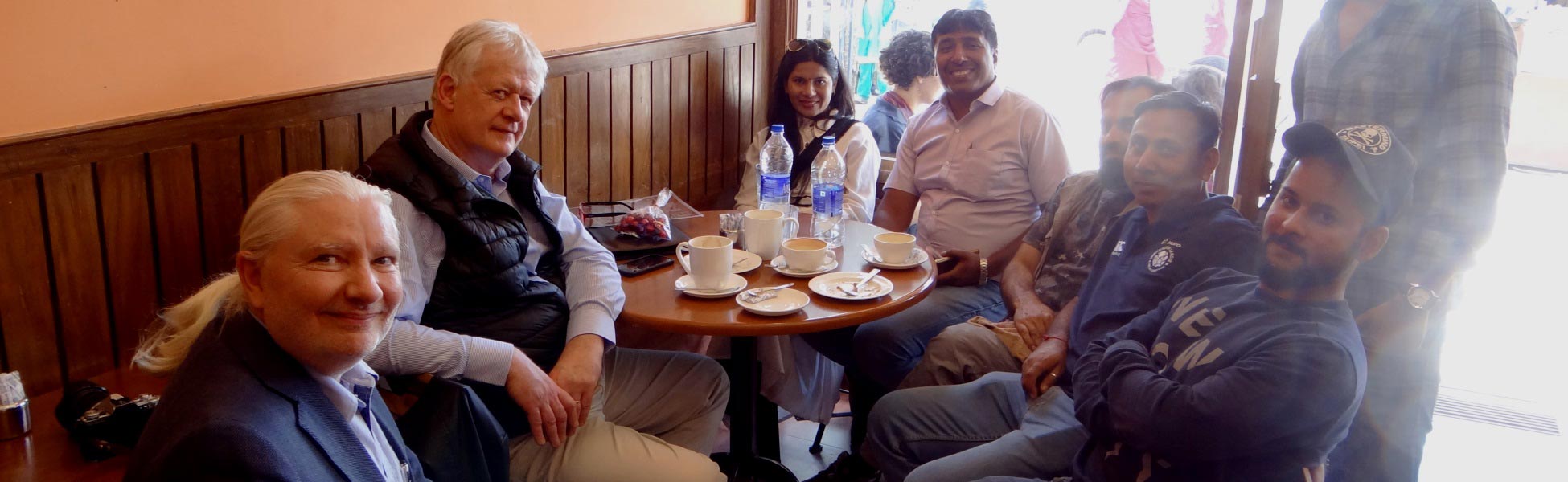 Trisna Films line production crew and international filmmakers sitting at a cafe table in McLeod Ganj Dharamshala during the shoot of Infinite Potential documentary. fixer in Bhadohi, film fixer in Bhadohi, media fixer in Bhadohi, movie fixer in Bhadohi, production fixer in Bhadohi, line producer in Bhadohi