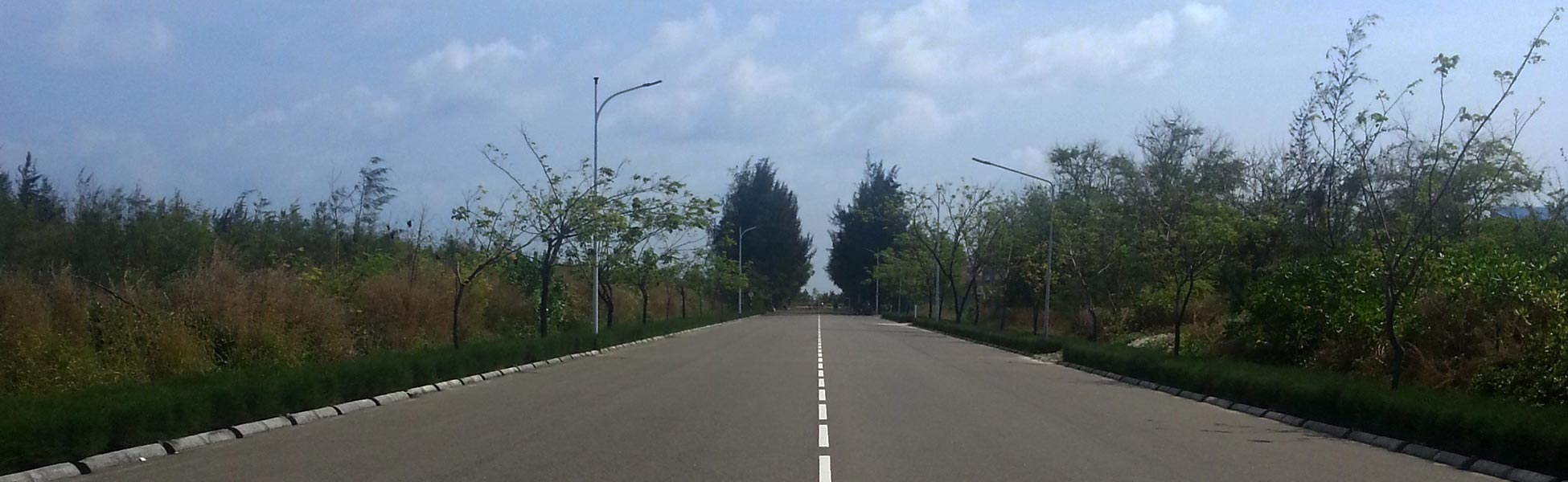 A perfectly symmetrical wide-angle shot of a modern asphalt road in Hulhumalé Phase 2, Maldives. Captured by Trisna Films®, this location features leading lines, tropical greenery, and clean minimalist infrastructure ideal for automotive or lifestyle cinematography. film shooting locations in Anuppur, video shooting locations in Anuppur, tv shooting locations in Anuppur, shooting locations in Anuppur