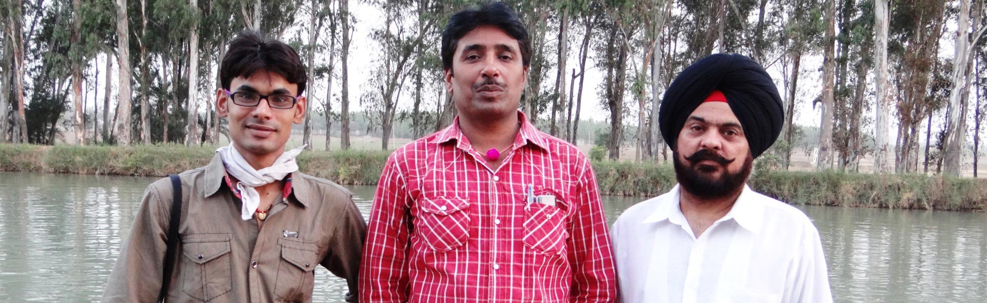 Three members of the Trisna Films® crew posing together by a water body during a corporate video production shoot in Ludhiana, Punjab, India. film production house in Argentina, video production house in Argentina, tv production house in Argentina, production house in Argentina, film production company in Argentina, video production company in Argentina, tv production company in Argentina, production company in Argentina