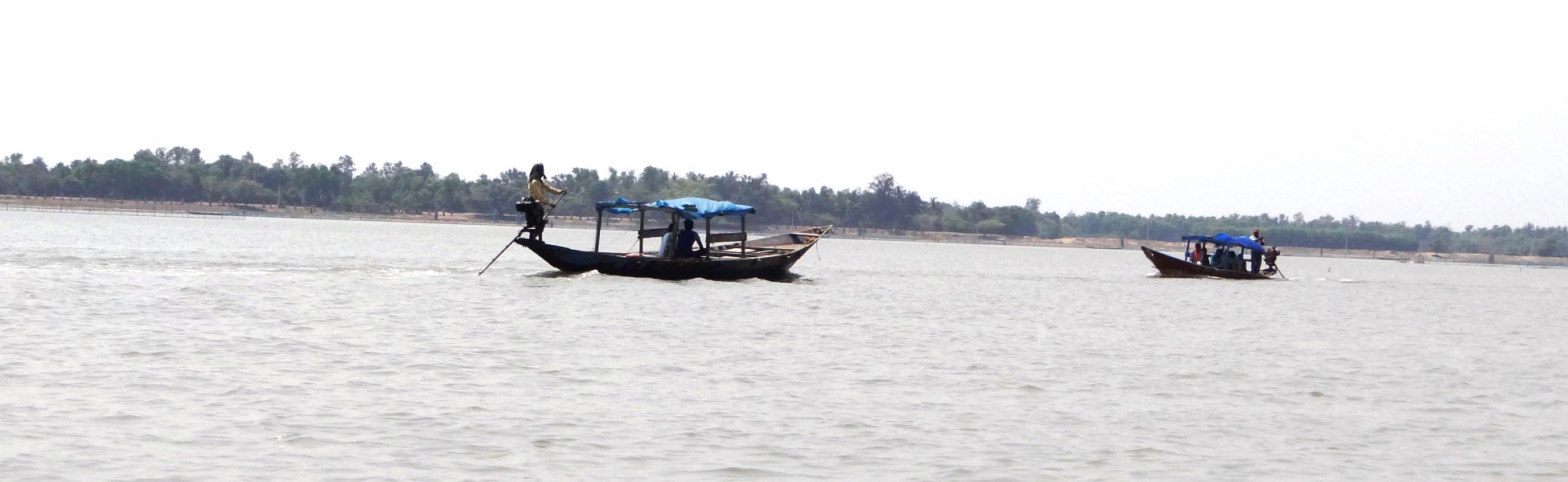 Wide shot of two traditional motorboats on the expanse of Chilika Lake lagoon in Odisha, India, curated as a premium film shooting location by Trisna Films®. film shooting locations in Bahrain, film shooting locations in manama, video shooting locations in Bahrain, video shooting locations in manama, tv shooting locations in Bahrain, tv shooting locations in manama, shooting locations in Bahrain, shooting locations in manama