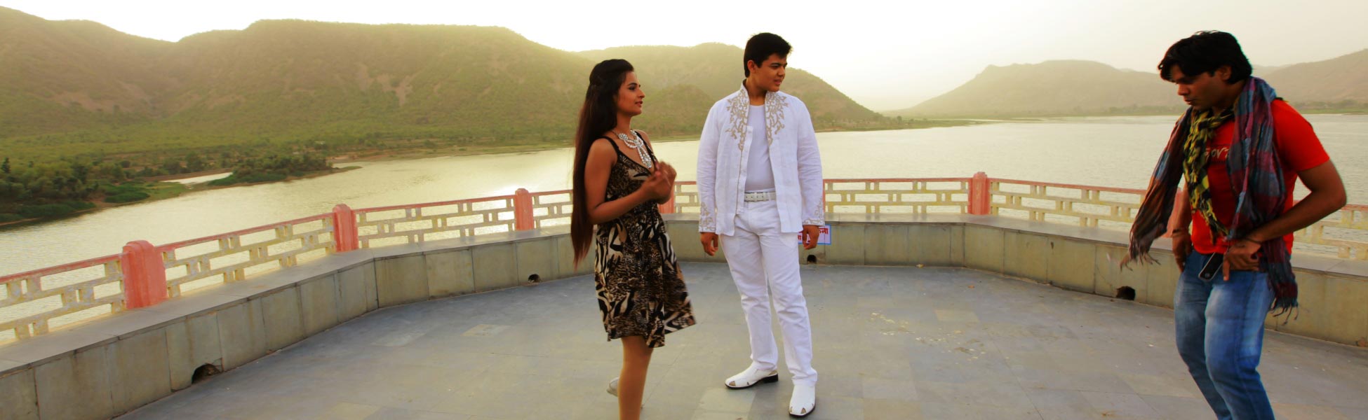 An Indian choreographer directing a male performer in a white embroidered outfit and a female performer in a patterned dress on an outdoor terrace overlooking a scenic lake and mountains during the shoot of the Indo-Uzbek music video 'Namun Chaa'. fixer in Bajali, fixer in pathsala, film fixer in Bajali, film fixer in pathsala, media fixer in Bajali, media fixer in pathsala, movie fixer in Bajali, movie fixer in pathsala, production fixer in Bajali, production fixer in pathsala, line producer in Bajali, line producer in pathsala