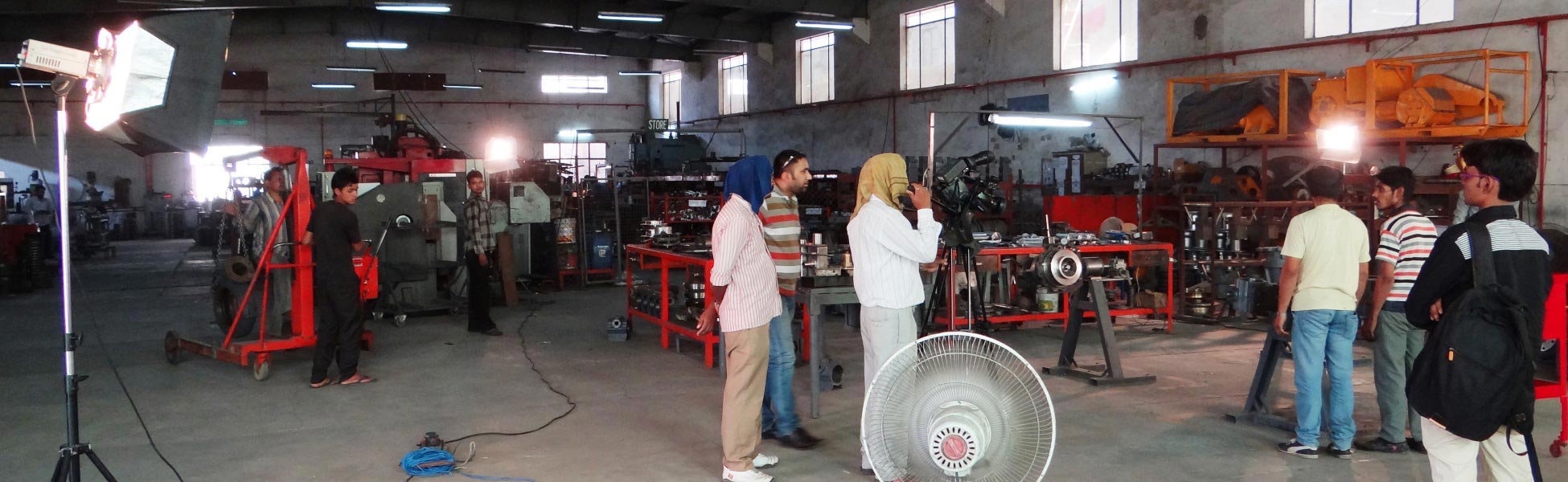 Professional camera crew and studio lighting setup filming a corporate promotional video inside an industrial manufacturing workshop floor in Ludhiana, Punjab. film production house in Ballari, video production house in Ballari, tv production house in Ballari, production house in Ballari, film production company in Ballari, video production company in Ballari, tv production company in Ballari, production company in Ballari