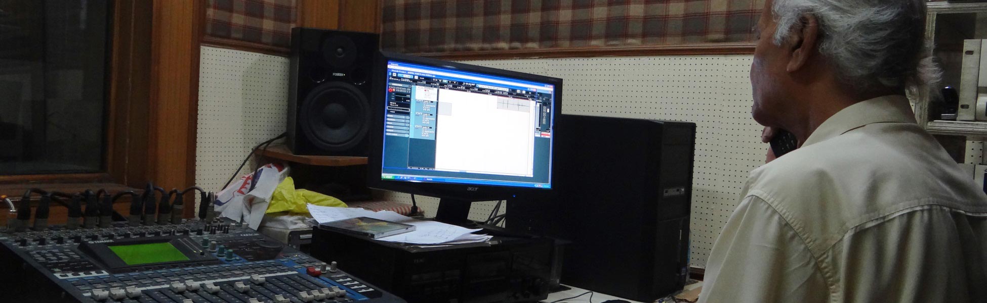 An experienced Indian sound engineer working at a digital audio recording studio console, monitoring a music production session on a DAW software screen. film production house in Balod, video production house in Balod, tv production house in Balod, production house in Balod, film production company in Balod, video production company in Balod, tv production company in Balod, production company in Balod